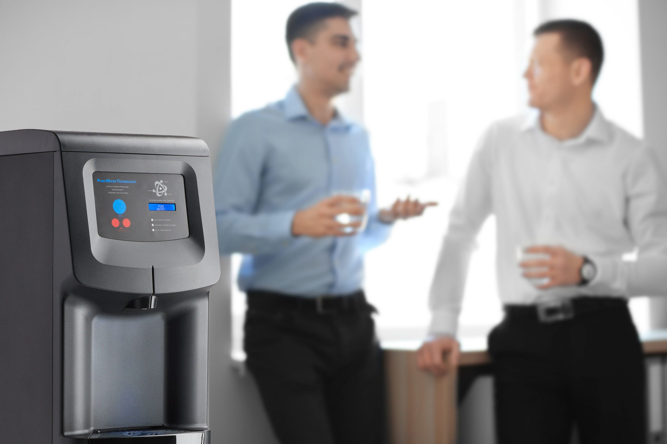 Office employees having break near water cooler