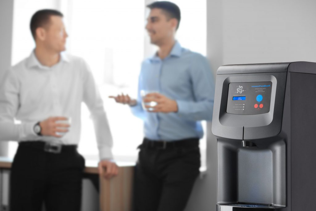 Team members talking behind a water cooler at the office