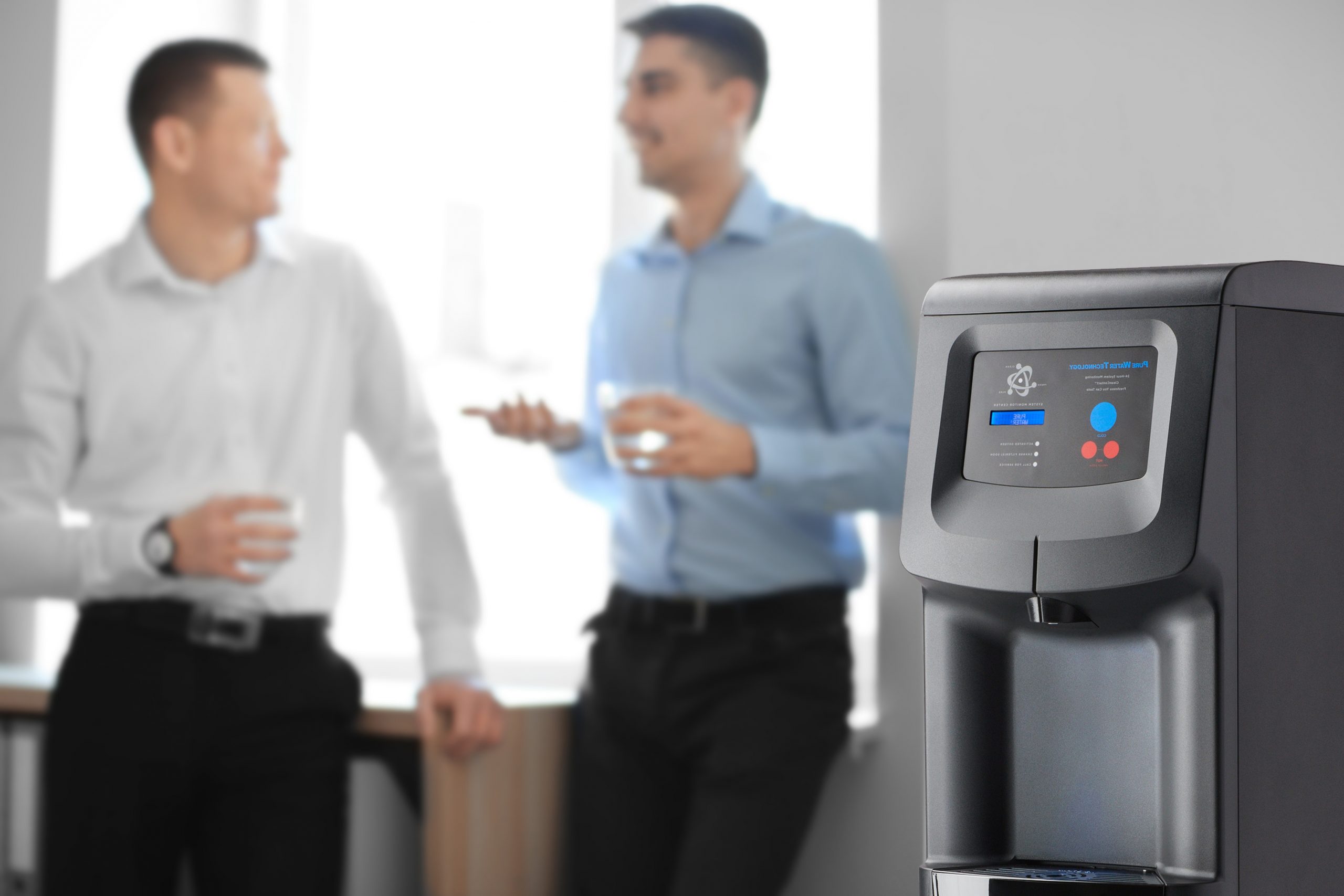 Office employees having break near water cooler