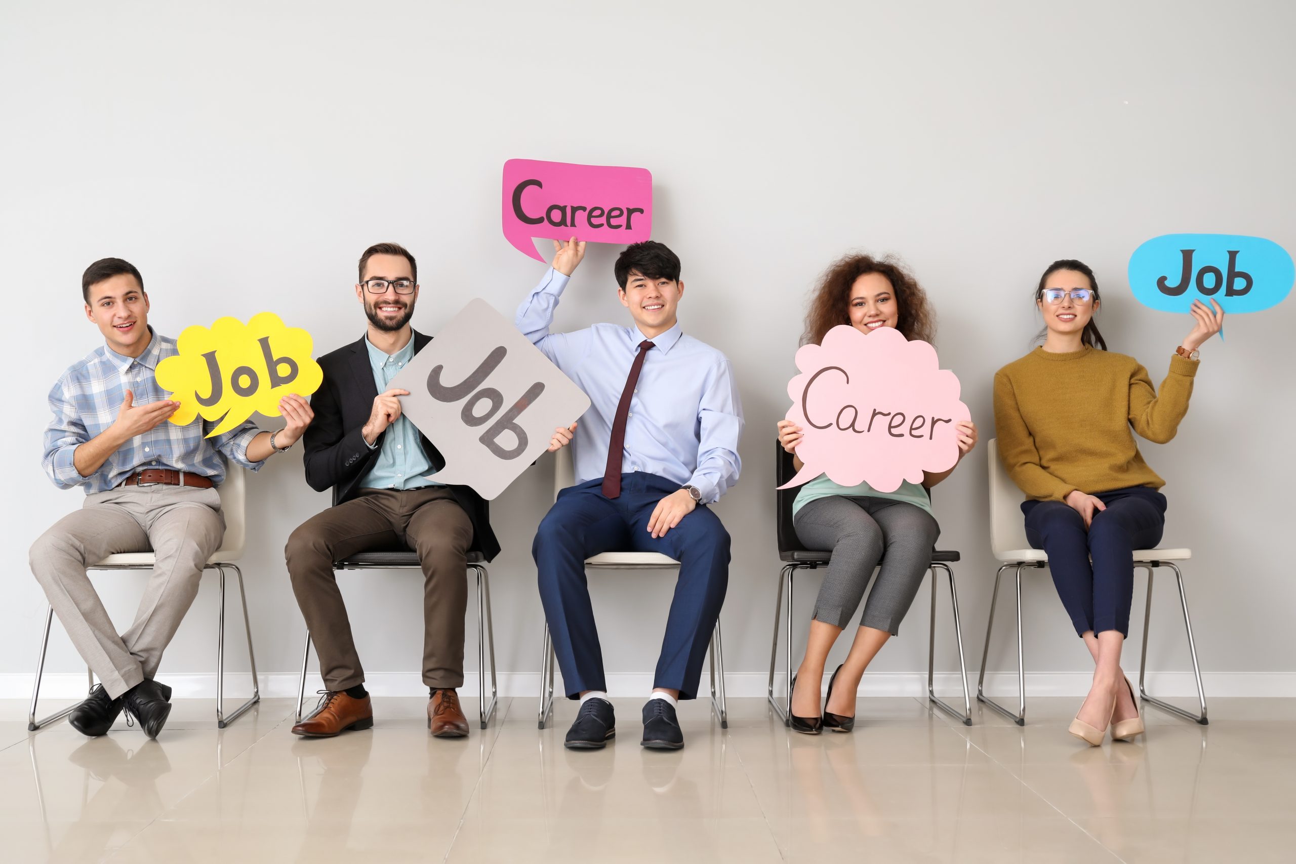 Young people holding speech bubbles with words JOB and CAREER indoors