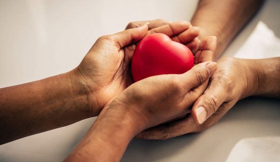 Helping hand of heart donor for patient in heart disease. Man give red heart to woman as couple. People lifestyle and couple romance. Healthcare and hospital medical concept. Symbolic of Valentine day