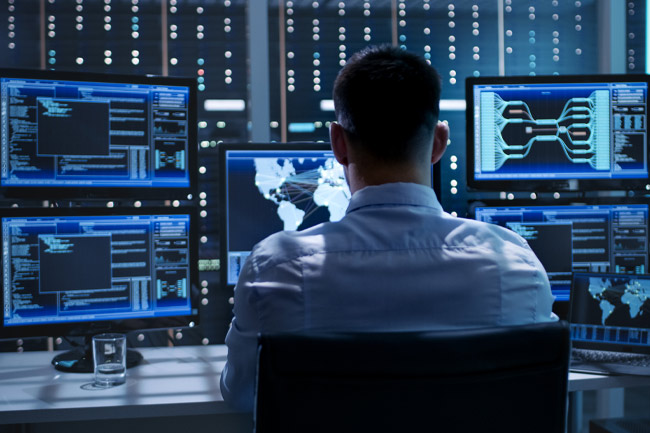 a man remotely monitoring systems and networks as part of managed cybersecurity