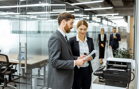 eam member on the office floor talking by the office copier