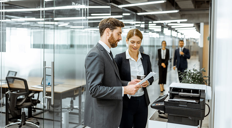 eam member on the office floor talking by the office copier