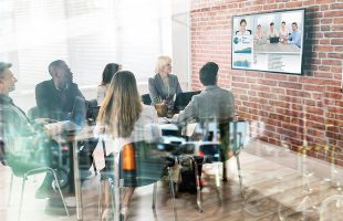 a team at the office and remote team members communicating via a video conferencing software