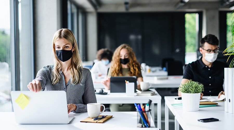 Employees with masks as a precautionary measure in an office during and after Covid-19