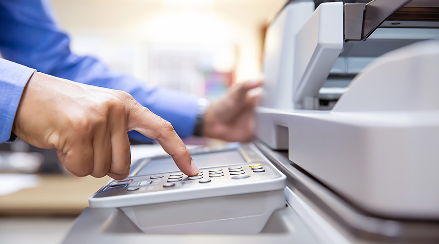 Printer brands: a man operating an office printer