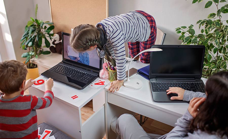 Future of Remote work challenges: a woman working remotely while her children climb the desk