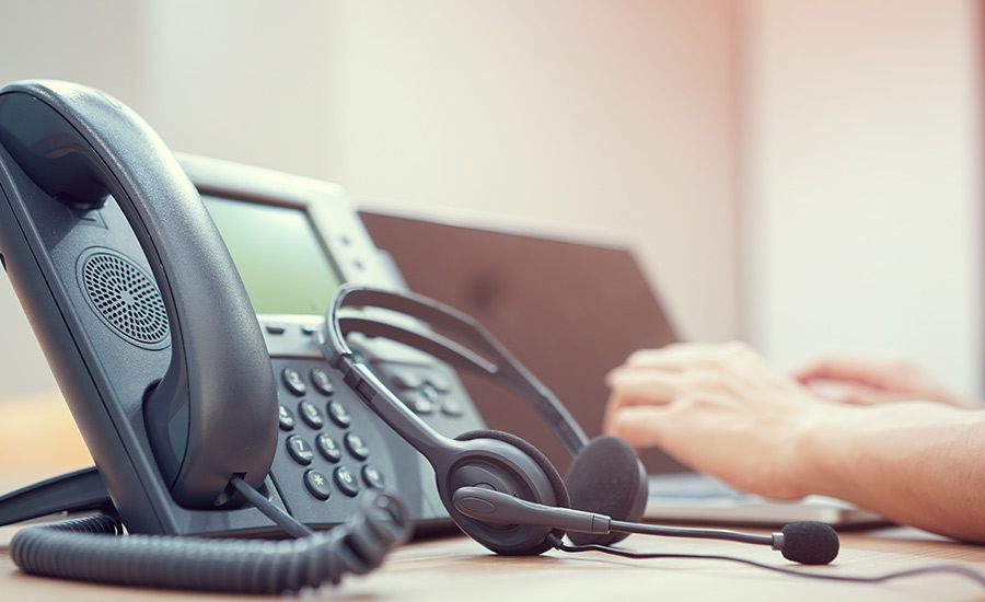 A desk phone with a headset next to it — elements of a VoIP solution