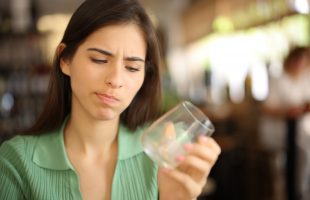Woman looking at empty glass.