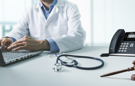 Doctor working on computer with voip system and gavel